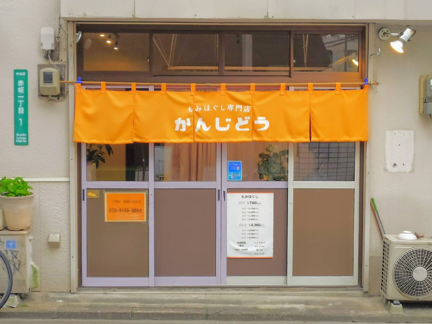 オレンジ色ののれんが目印の、かんじどう店舗外観